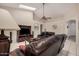 Inviting living room featuring tile flooring, leather sofas and a ceiling fan at 16811 S 11Th Way, Phoenix, AZ 85048