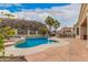 A glistening pool is nestled between natural rock outcroppings and mature palm trees at 16811 S 11Th Way, Phoenix, AZ 85048