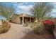 Expansive backyard with lush landscaping, a covered patio, and a neutral rock ground cover for easy maintenance at 17555 W Glenhaven Dr, Goodyear, AZ 85338