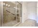 The bathroom features a glass door shower with a built-in seat and neutral tile surround at 17555 W Glenhaven Dr, Goodyear, AZ 85338