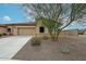 Attractive single-story home featuring a two-car garage and a xeriscaped front yard with mature landscaping at 17555 W Glenhaven Dr, Goodyear, AZ 85338