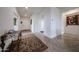 Inviting foyer with neutral tile floors, elegant rugs, and crisp white walls leading to other rooms at 17555 W Glenhaven Dr, Goodyear, AZ 85338