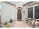 Charming front entrance with a decorative metal door, potted plants, and a cozy bench, creating a warm welcome at 18282 N 92Nd St, Scottsdale, AZ 85255