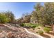 A large backyard features mature trees, a rock garden and a view of the house at 18421 N 12Th Way, Phoenix, AZ 85022