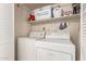 Bright laundry room with white appliances, shelf storage and white folding door at 18421 N 12Th Way, Phoenix, AZ 85022