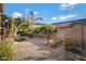 Low-maintenance desert backyard featuring palm trees, gravel landscaping, and a privacy wall at 19025 E Raven Dr, Queen Creek, AZ 85142