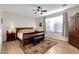 Bedroom with a wooden sleigh bed, an area rug, and wood-look floors at 19025 E Raven Dr, Queen Creek, AZ 85142