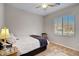 Bedroom with light walls, a ceiling fan, wood-look flooring, and a window at 19025 E Raven Dr, Queen Creek, AZ 85142