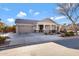 Inviting single-story home featuring a well-kept lawn, covered porch, and two-car garage at 19025 E Raven Dr, Queen Creek, AZ 85142