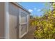 A wooden storage shed with a gravel path, framed by vibrant green foliage under a clear blue sky at 19025 E Raven Dr, Queen Creek, AZ 85142