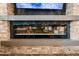 Modern linear fireplace with a stone surround and glass embers, providing warmth and ambiance to the living space at 20551 E Mayberry Rd, Queen Creek, AZ 85142