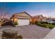 Exterior showcasing the garage with a brick driveway and manicured landscaping under a colorful sky at 20551 E Mayberry Rd, Queen Creek, AZ 85142