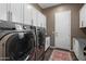 Well-equipped laundry room features modern LG washer and dryer, with ample storage cabinets above at 20551 E Mayberry Rd, Queen Creek, AZ 85142