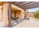 Charming outdoor patio area with a pergola, lush greenery, and a cozy fire pit at 2075 S Ponderosa Dr, Gilbert, AZ 85295