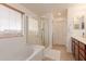 Bright bathroom featuring a shower, soaking tub, and wood-look cabinets at 2075 S Ponderosa Dr, Gilbert, AZ 85295