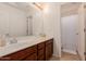 Bright bathroom with a large mirror, vanity, and a doorway leading to the shower with a white curtain at 2075 S Ponderosa Dr, Gilbert, AZ 85295