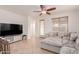 Bright living room featuring neutral tones, a ceiling fan, tile floors, and a comfortable sectional at 2075 S Ponderosa Dr, Gilbert, AZ 85295