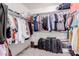 Well-organized walk-in closet with ample storage, hanging rods, and luggage at 2075 S Ponderosa Dr, Gilbert, AZ 85295