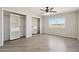 Spacious bedroom featuring wood-look floors, natural light, and walk in closets with built-in shelves at 21189 E Blue Jay Ln, Florence, AZ 85132