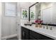 Stylish bathroom with a dark vanity, white countertop, and a framed botanical art print at 21413 N 59Th St, Phoenix, AZ 85054