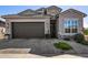 Charming home exterior with a brown garage door, well-maintained landscaping, and stone accents at 21413 N 59Th St, Phoenix, AZ 85054