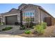 Charming home exterior with a brown garage door, well-maintained landscaping, and stone accents at 21413 N 59Th St, Phoenix, AZ 85054