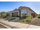 Charming home exterior with a brown garage door, well-maintained landscaping, and stone accents at 21413 N 59Th St, Phoenix, AZ 85054