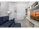 Living area showcasing a blue sofa, white built-in shelving, and access to multiple doors at 21413 N 59Th St, Phoenix, AZ 85054