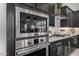 Close-up of a stainless steel oven and microwave featuring black cabinetry and subway tile backsplash at 21413 N 59Th St, Phoenix, AZ 85054