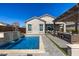 A backyard pool with a waterfall feature and outdoor seating area under a pergola at 21413 N 59Th St, Phoenix, AZ 85054