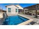 A backyard pool with a waterfall feature and outdoor seating area under a pergola at 21413 N 59Th St, Phoenix, AZ 85054