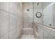 Spacious walk-in shower with gray tiled walls, a glass door, and a built-in niche for toiletries at 21413 N 59Th St, Phoenix, AZ 85054