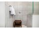 Modern walk-in shower showcases gray tiles, a wooden bench, and contemporary fixtures, creating a spa-like retreat at 21413 N 59Th St, Phoenix, AZ 85054