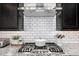 Close-up of a gas stovetop with a stainless steel range hood and subway tile backsplash at 21413 N 59Th St, Phoenix, AZ 85054