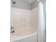 Shower-tub combo with white tiled wall and floors at 24431 N 35Th Dr, Glendale, AZ 85310