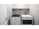 Modern laundry room featuring a side by side washer and dryer and overhead shelving at 24431 N 35Th Dr, Glendale, AZ 85310