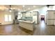 Bright, open kitchen features white cabinetry, granite counters, tile backsplash, and an island with cooktop at 26637 S New Town Dr, Sun Lakes, AZ 85248