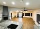 Inviting living room featuring a fireplace, wood-look tile flooring, and adjacent kitchen area at 26637 S New Town Dr, Sun Lakes, AZ 85248