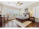 Bright bedroom showcasing plantation shutters, hardwood floors, and a king-size bed at 29588 N 129Th Dr, Peoria, AZ 85383