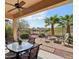 Relaxing covered patio with ceiling fans, stylish outdoor furniture, and beautiful views of the surrounding desert landscape at 29588 N 129Th Dr, Peoria, AZ 85383