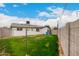 Fenced backyard featuring a well manicured grassy area, block fence, and rear house elevation at 3009 W Alice Ave, Phoenix, AZ 85051