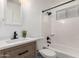 Updated bathroom with modern fixtures and a wood vanity, featuring black hardware, a tub and shower with white subway tile at 3009 W Alice Ave, Phoenix, AZ 85051