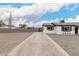 Long driveway leading to a renovated single-story home with crisp white paint and xeriscaped yard at 3009 W Alice Ave, Phoenix, AZ 85051