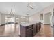 Stylish kitchen island area open to a spacious room with a modern chandelier, laminate flooring, and patio access at 318 E Gail Dr, Gilbert, AZ 85296