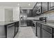 Modern kitchen with stainless steel appliances, dark cabinetry, and a stylish tiled backsplash for added appeal at 3263 S Miller Dr, Chandler, AZ 85286