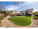 The well-manicured backyard features a sparkling pool, lush lawn, and multiple entertainment areas at 3274 E Isaiah Ct, Gilbert, AZ 85298