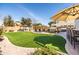 Expansive backyard with a pool, covered seating, and lush green space, creating an ideal outdoor oasis at 3274 E Isaiah Ct, Gilbert, AZ 85298