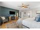 Spacious main bedroom features wood floors, blue accent wall with a fireplace and ceiling fan at 3274 E Isaiah Ct, Gilbert, AZ 85298