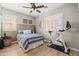 Comfortable bedroom featuring wood floors, plantation shutters, a ceiling fan, and a stationary bicycle at 3274 E Isaiah Ct, Gilbert, AZ 85298