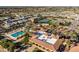 Aerial view of the community pool with palm trees, lush landscaping, tennis courts and a well-maintained clubhouse at 3274 E Isaiah Ct, Gilbert, AZ 85298